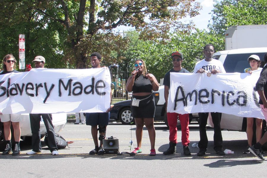 Protestors made a banner reading “Slavery made America great’ in response to Trump’s catchphrase, “Make America great again.” Many residents in the community came out to voice that they do not believe Trump can ever reach out to most African-American voters. /Ruthann Alexander