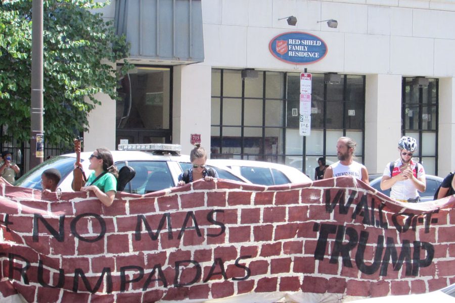 Protesters unfurled a banner painted like a brick wall to symbolize their disdain for having Trump in Philadelphia. Many voters, including the African-American and immigrant communities, find Trump’s words and actions offensive, especially his idea to build a wall at the border of Mexico and make Mexico pay for it./Ruthann Alexander