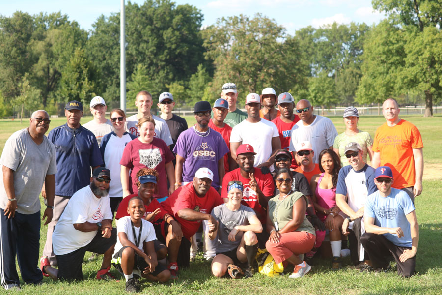 Organizers, players, family members, and both teams pose for a photo after an afternoon of baseball at the 10th annual Step Up to the Plate: Strike Out Violence softball game. /Kaitlyn Moore