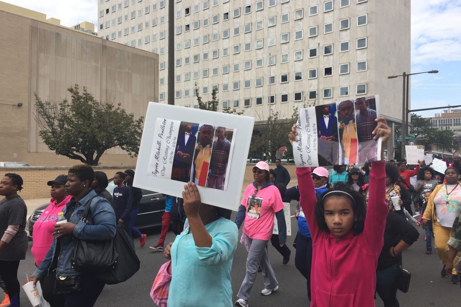 Mothers and children carried signs and photos of their lost brothers, sons and fathers while they marched down Broad Street. 